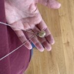 Dlouhý skleněný náhrdelník Snitch Wired na krku